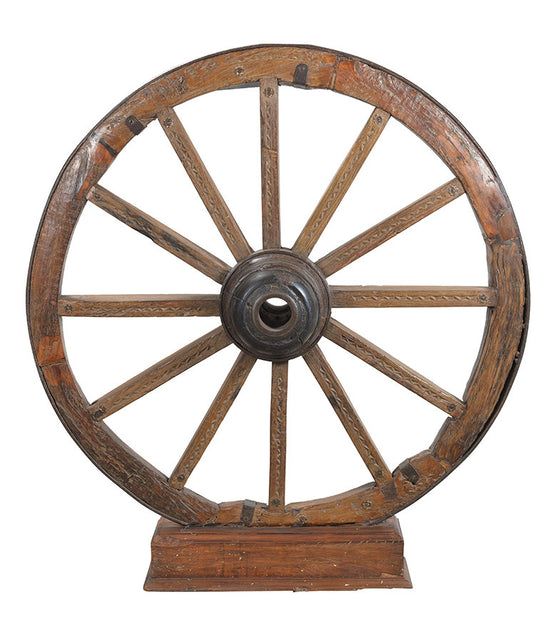 Old charriot wheel on stand//Ancienne roue de chariot sur pied